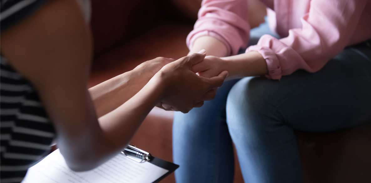 Two women holding hands showing compassion